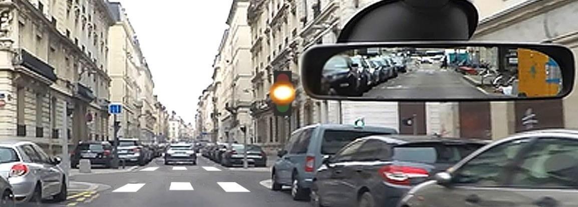 На міській вулиці видно перехрестя зі світлофором, що працює в режимі миготіння жовтого сигналу. Це означає, що перехрестя є небезпечним і нерегульованим.