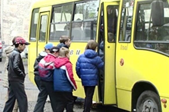 До автобуса підходять діти для посадки або висадки. Це ситуація з організованою групою дітей біля транспортного засобу.
