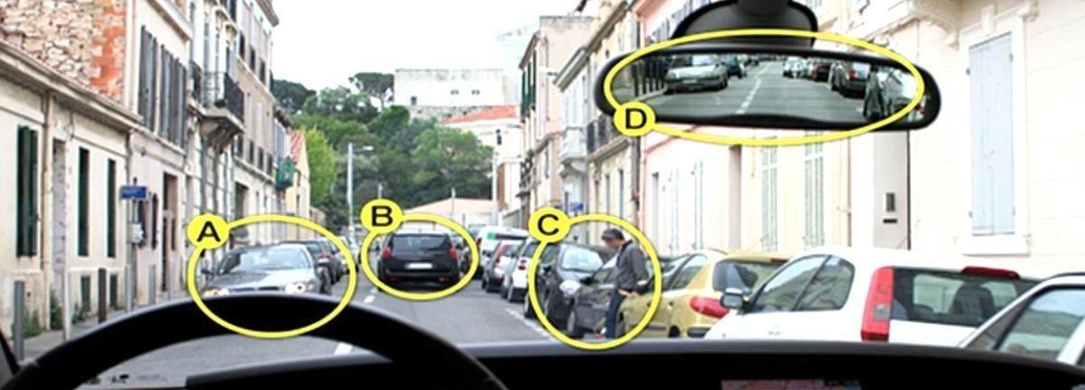 Вузька міська вулиця з припаркованими автомобілями по обидва боки. Біля правого ряду стоїть пішохід поруч із відчиненими дверима авто, а в дзеркалі видно рух позаду.