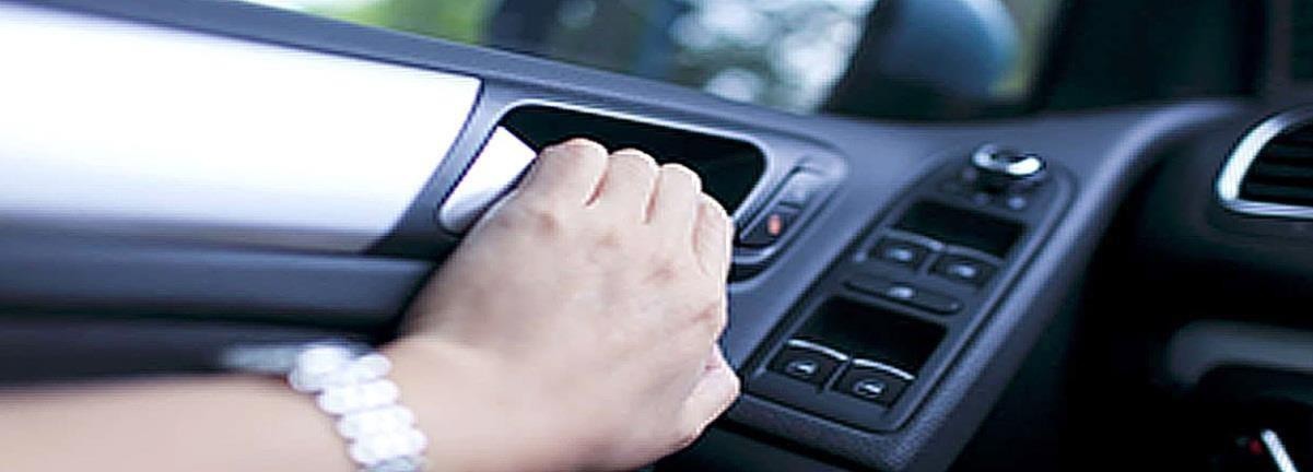 На фото рука відкриває двері автомобіля з боку проїзної частини.