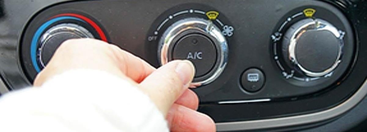 На фото панель керування кліматом автомобіля, рука вмикає кондиціонер A/C.